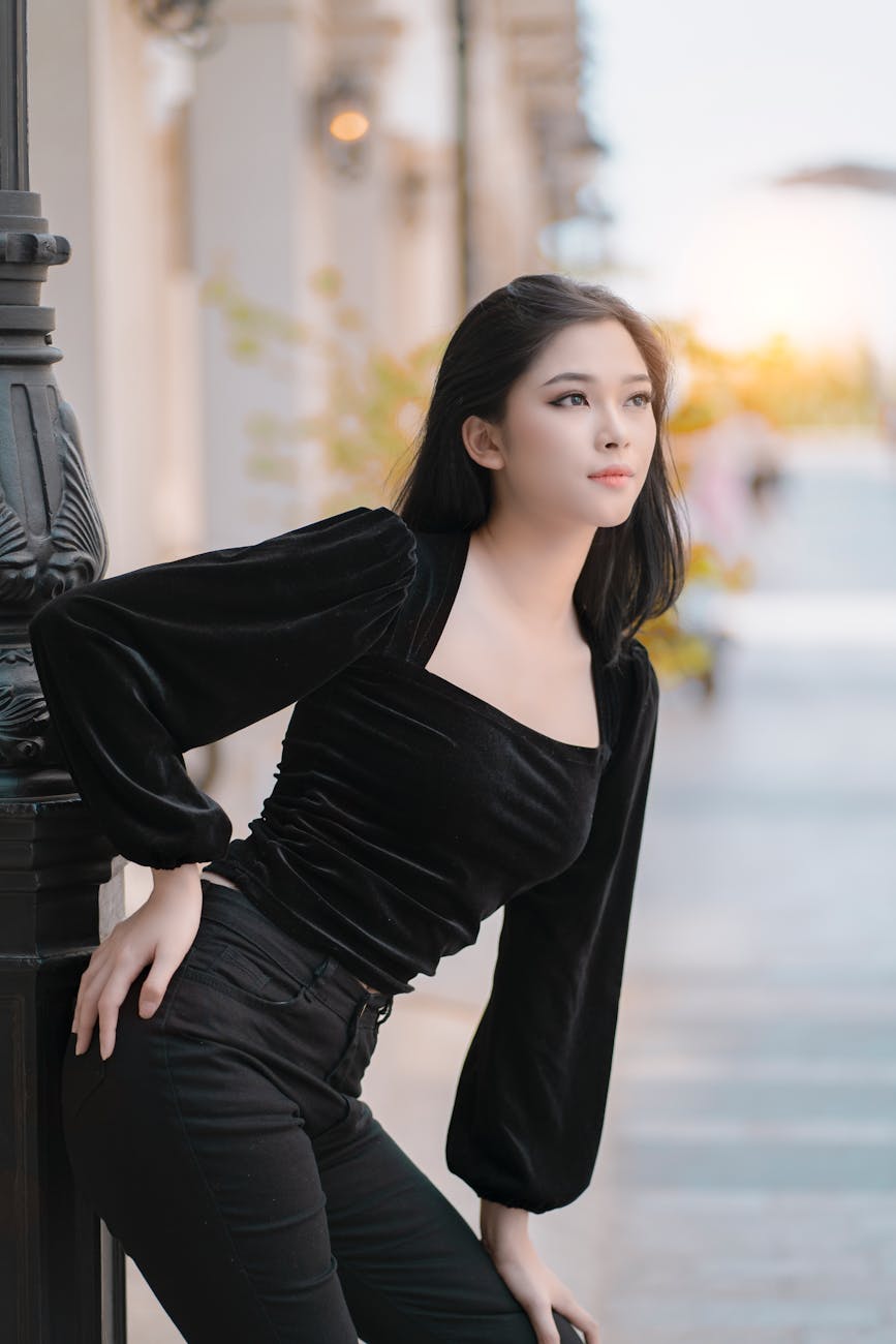 stylish asian woman standing gracefully on street sidewalk